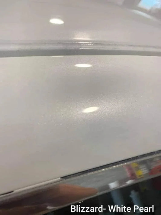 Close-up of Blizzard White Pearl metallic car paint finish with reflective shine