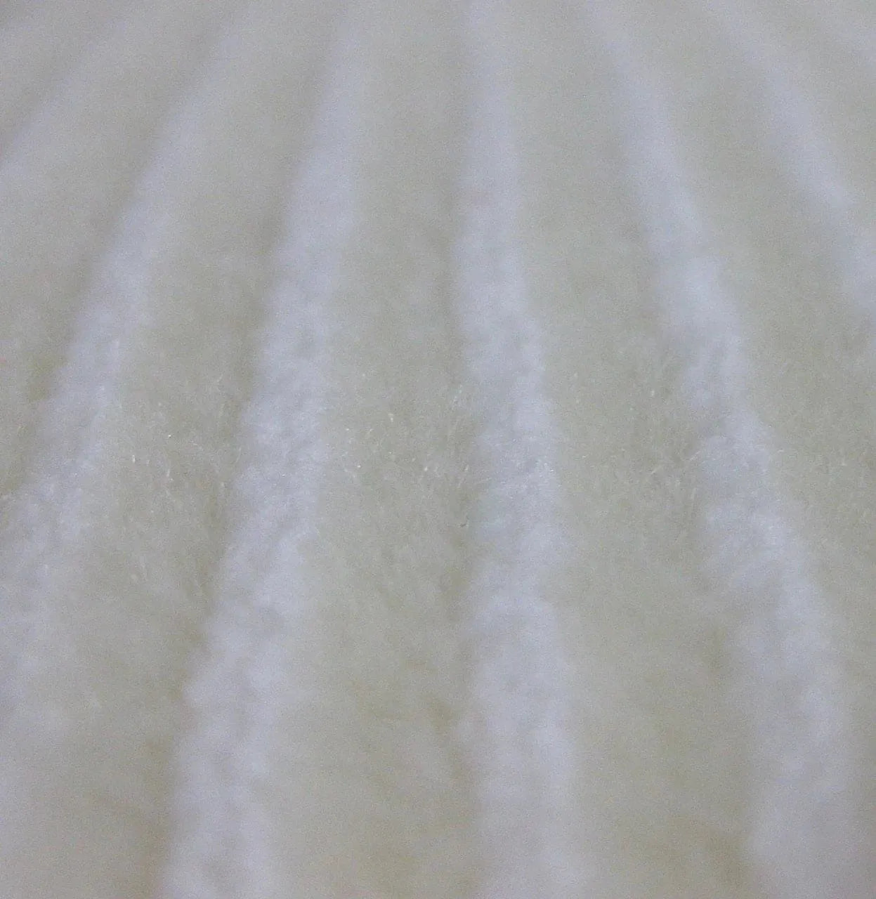 Close-up of white hybrid microfiber wool fabric with textured ridges