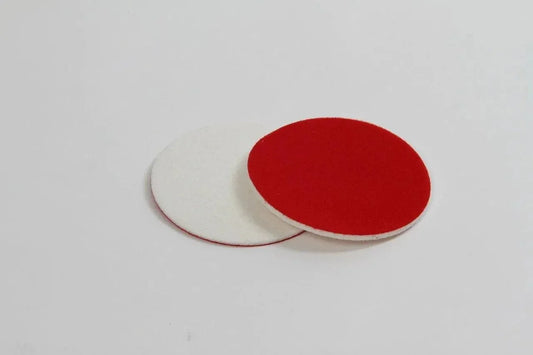 Two round CarPro glass rayon polishing pads, one red and one white, on a plain white background