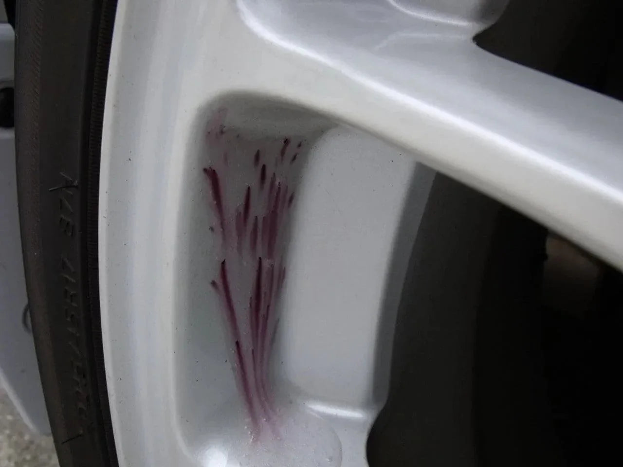White car alloy wheel with purple iron fallout remover gel applied for cleaning purposes