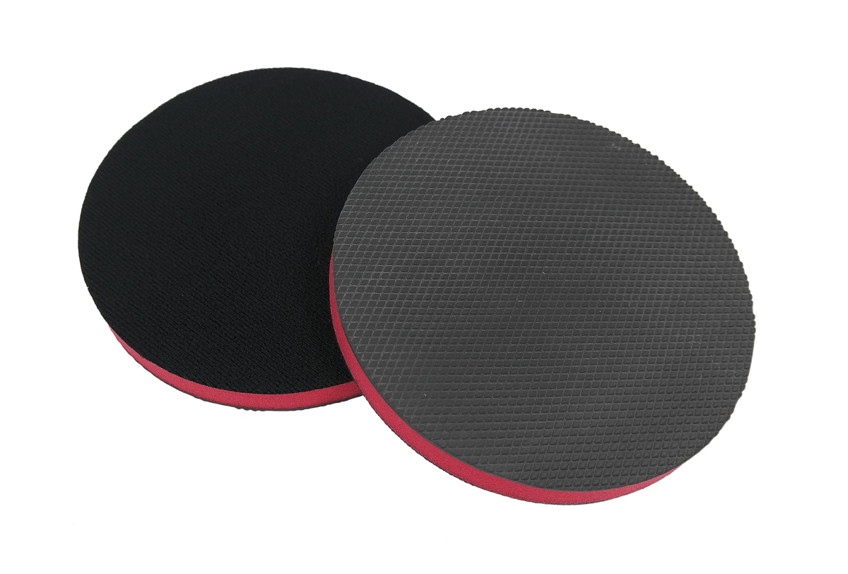 Two circular CarPro Polyshave Decon sanding discs with textured black surfaces and red edges on white background
