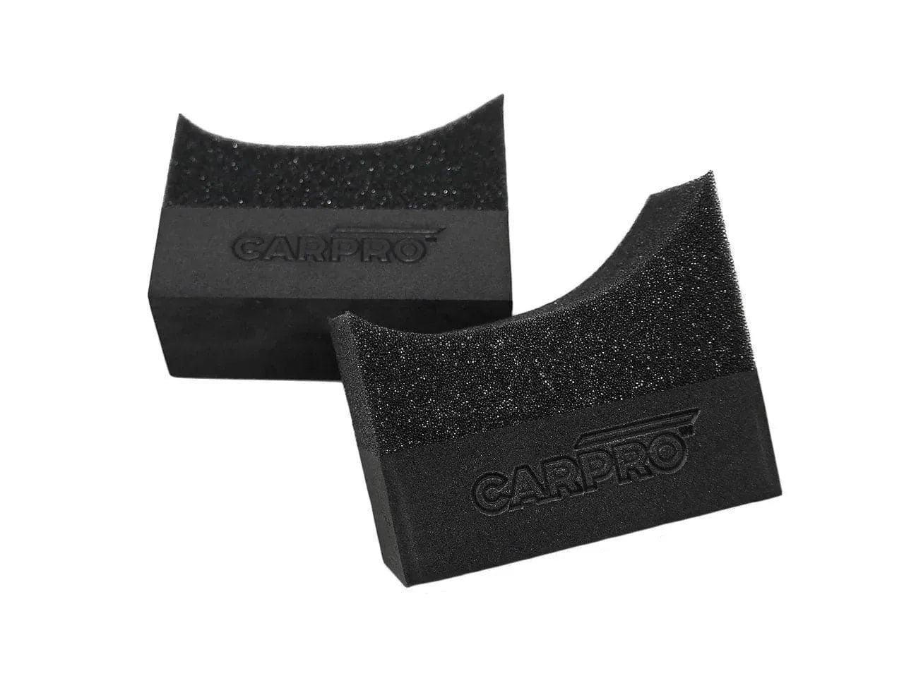 Two black CarPro tire swipe applicators with textured foam pads on a white background