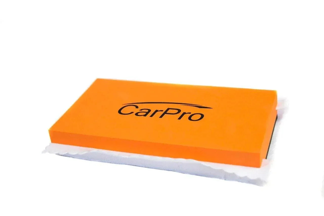 Orange CarPro Cquartz applicator block on white background for car detailing