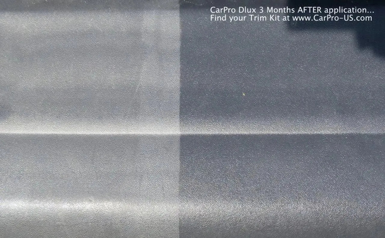 Comparison of black vehicle trim showing faded untreated side and dark restored side after CarPro Dlux application