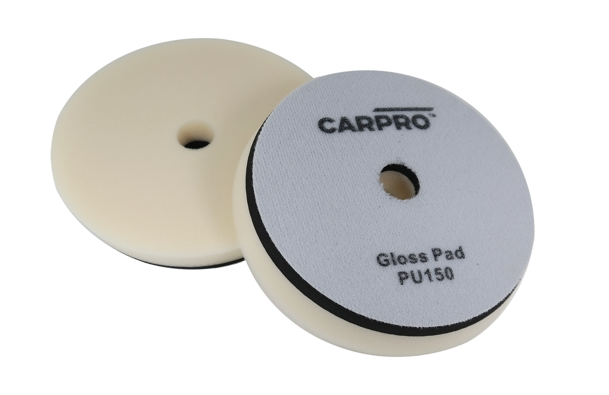Two CarPro Gloss Pads PU125 foam polishing pads with central holes on a white background