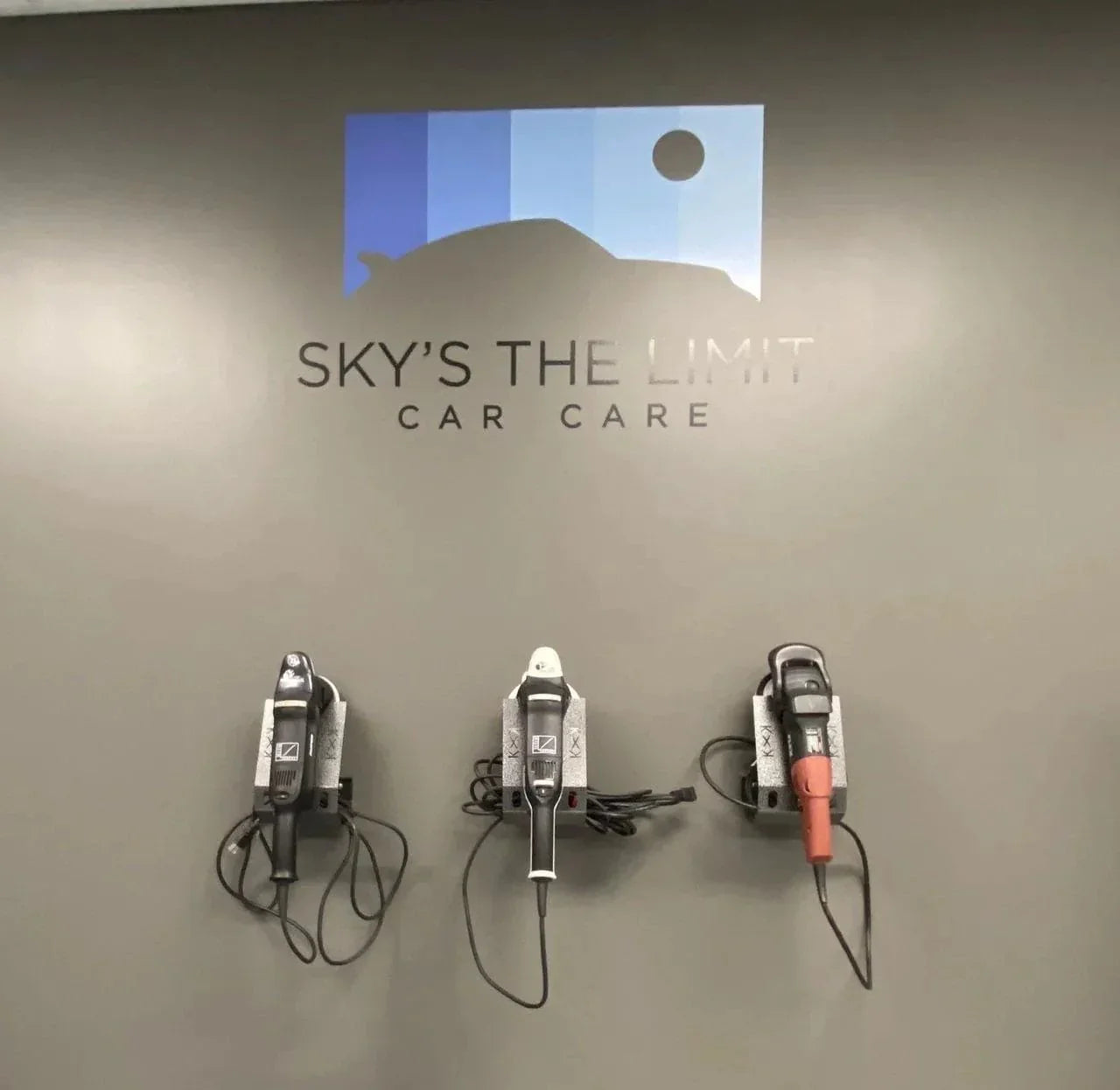 Three wall-mounted car polishing tools beneath blue logo with car silhouette and Sky's the Limit Car Care text
