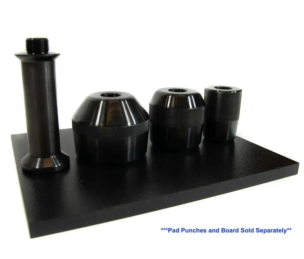 Set of four black metal pad punches on a flat black surface for leather crafting