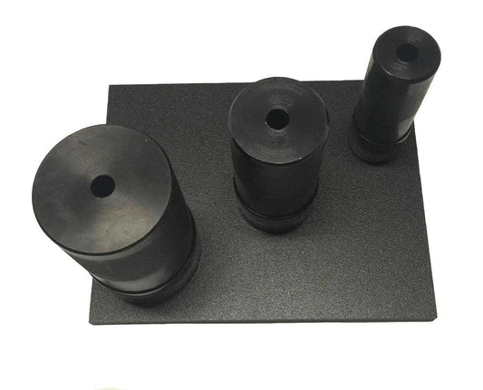 black rubber punch board with three cylindrical punch tools of different sizes on textured base