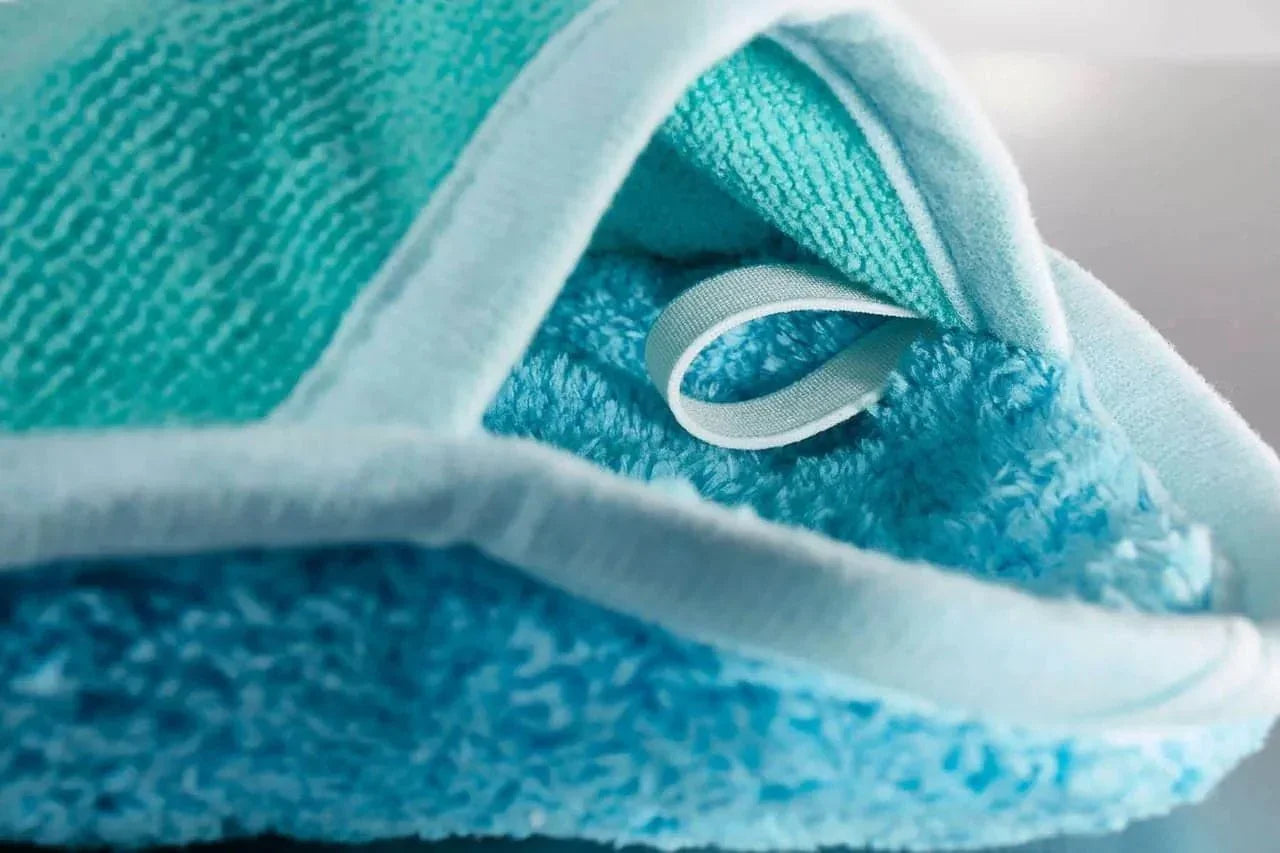 Close-up of blue microfiber cleaning cloth with white trim and hanging loop