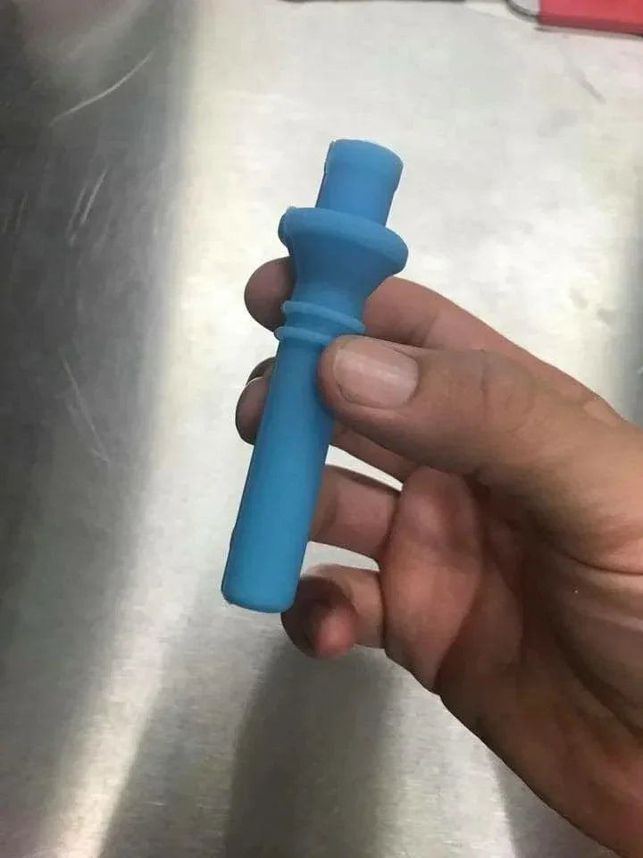 Hand holding a blue silicone lug plug masking tool against a metallic surface