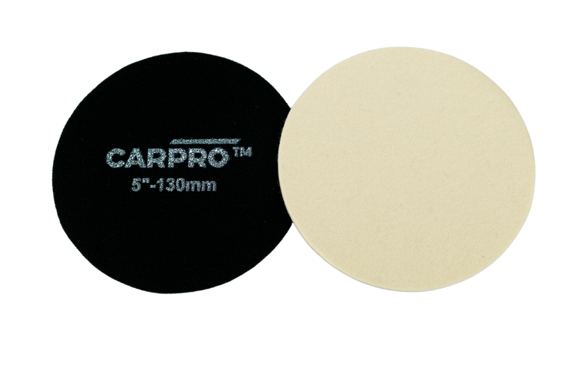 Two CarPro glass rayon polishing pads, one red side up and one white side up, on a white background