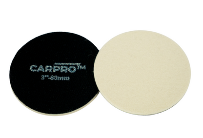 Two CarPro glass rayon polishing pads, one red side up and one white side up, on a white background