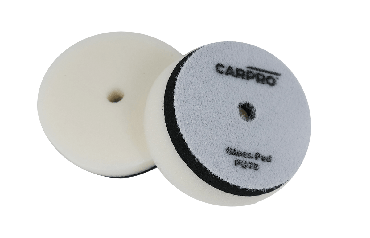 Two CarPro Gloss Pads PU125 foam polishing pads with central holes on a white background