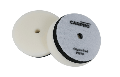 Two CarPro Gloss Pads PU125 foam polishing pads with central holes on a white background