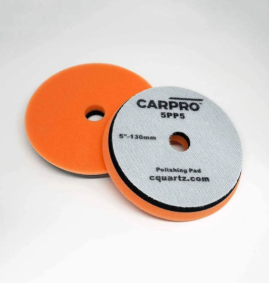 Two orange CarPro polishing pads, 5-inch, with one showing the white backing and brand text