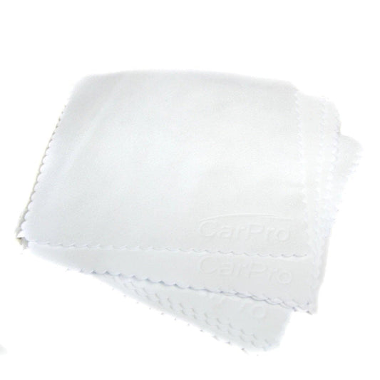 Stack of white CarPro suede microfiber cloths with scalloped edges on white background