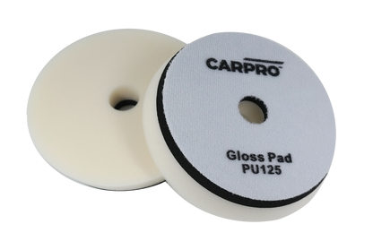 Two CarPro Gloss Pads PU125 foam polishing pads with central holes on a white background