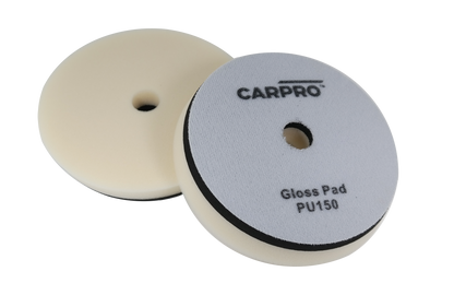 Two CarPro Gloss Pads PU125 foam polishing pads with central holes on a white background