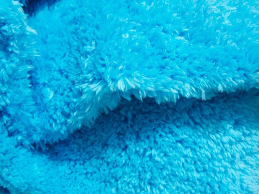 Close-up of bright blue microfiber cloth with soft textured fibers for cleaning