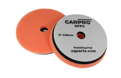 Pair of orange CarPro polishing pads with center holes and gray backing