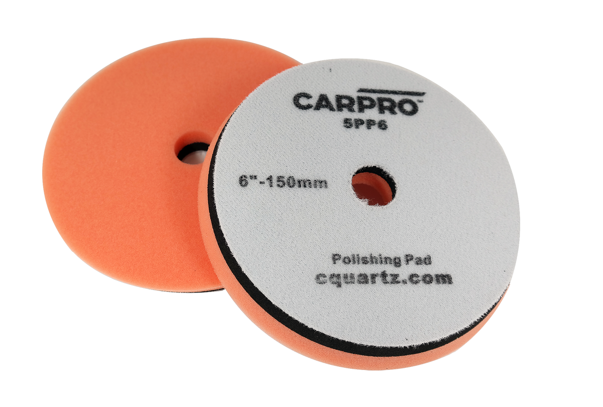Pair of orange CarPro polishing pads with center holes and gray backing