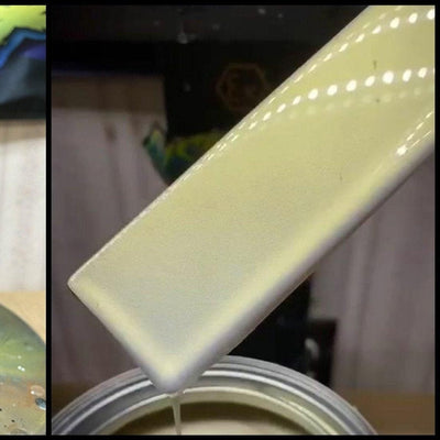 Close-up of a glossy cream-yellow paint sample on a test stick over a paint can